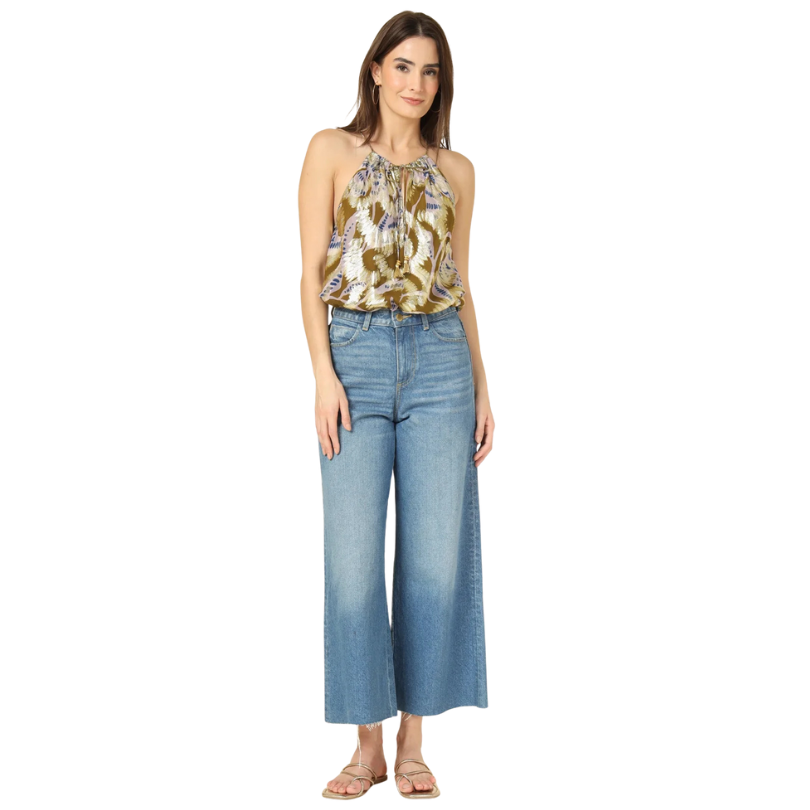 Woman wearing a floral top and blue jeans on a white background