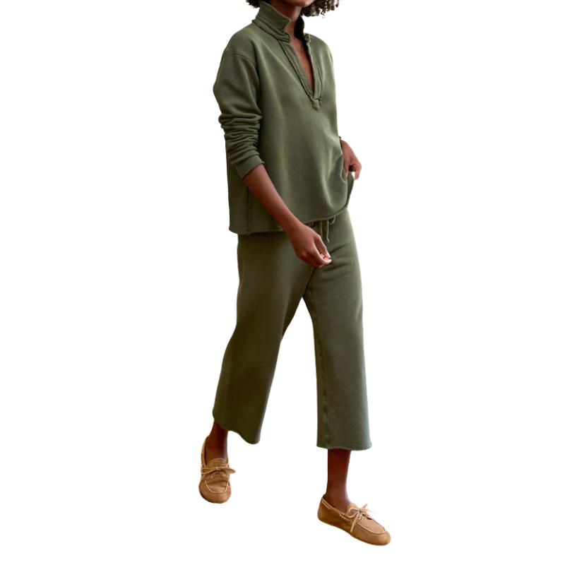 Person wearing a green outfit with brown shoes on a white background