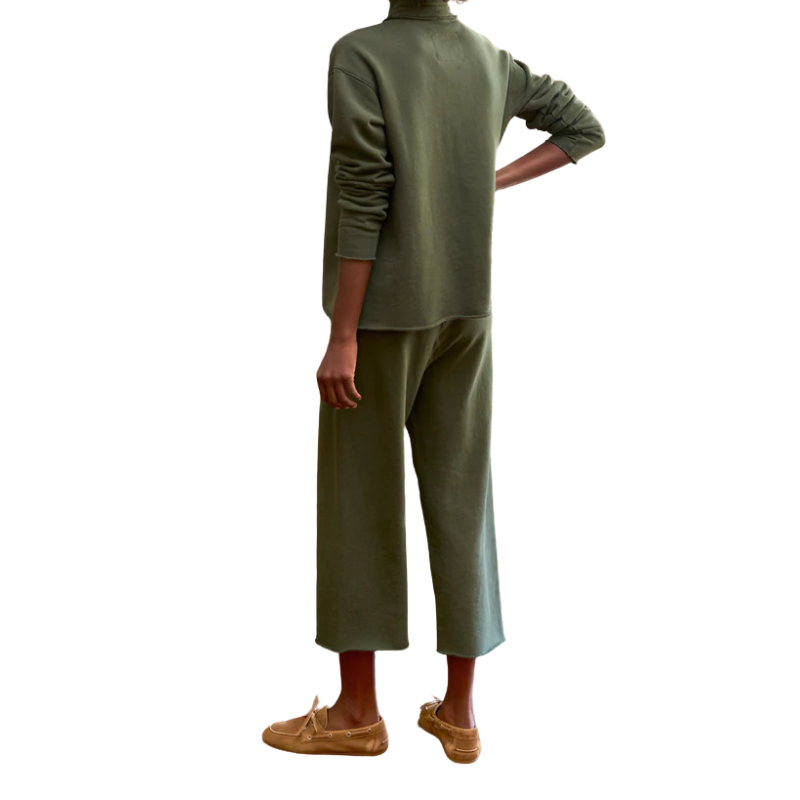 Person wearing a green outfit with a plain white background