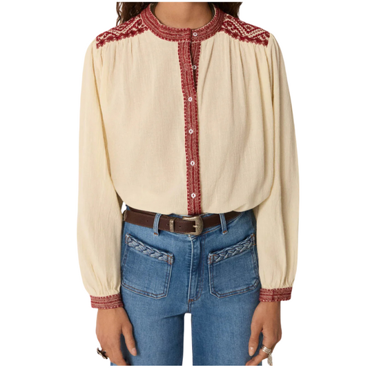 Beige blouse with red embroidery and blue jeans on a white background
