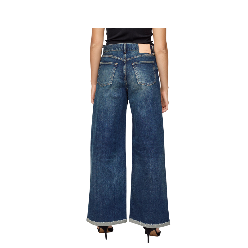 Person wearing blue wide-leg jeans on a white background