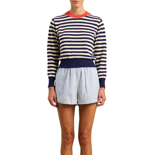Person wearing a striped sweater and skirt on a white background