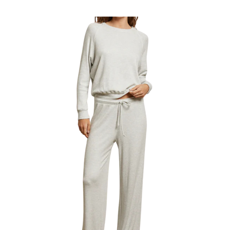 Person wearing a light gray sweatshirt and pants on a white background