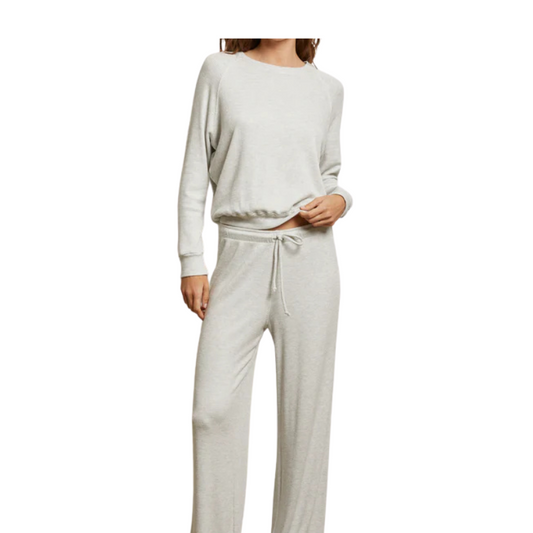 Person wearing a light gray sweatshirt and pants on a white background