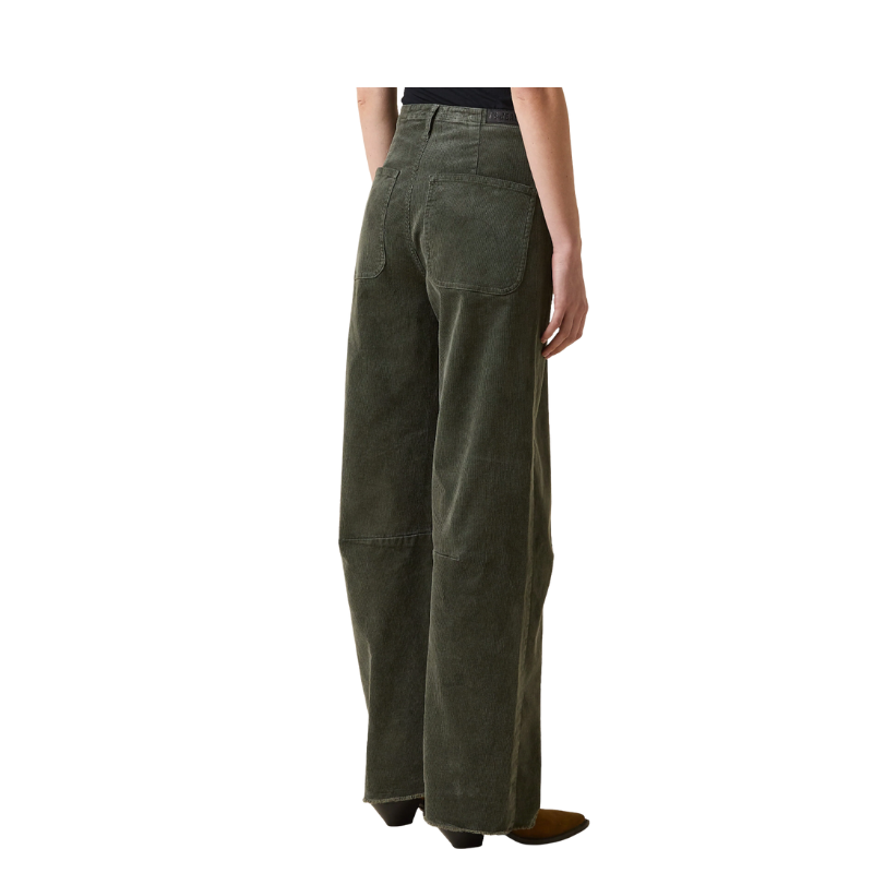 Green corduroy pants worn by a person on a white background