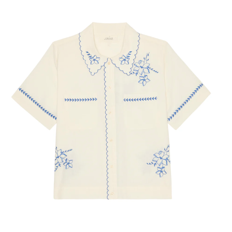 Beige shirt with blue floral embroidery on a white background