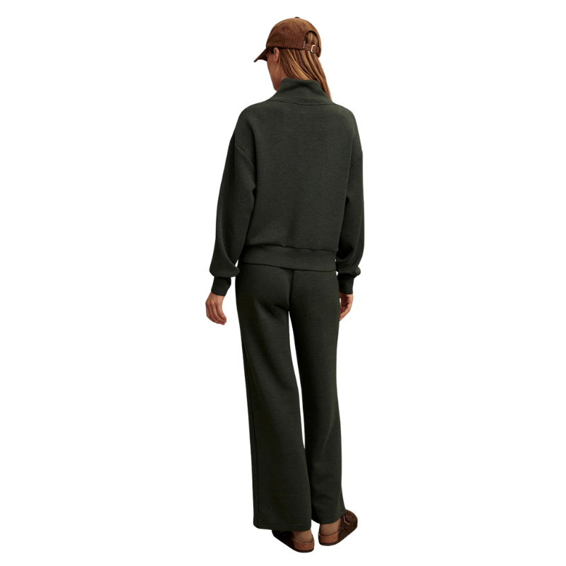 Person wearing a dark green outfit with a cap on a white background