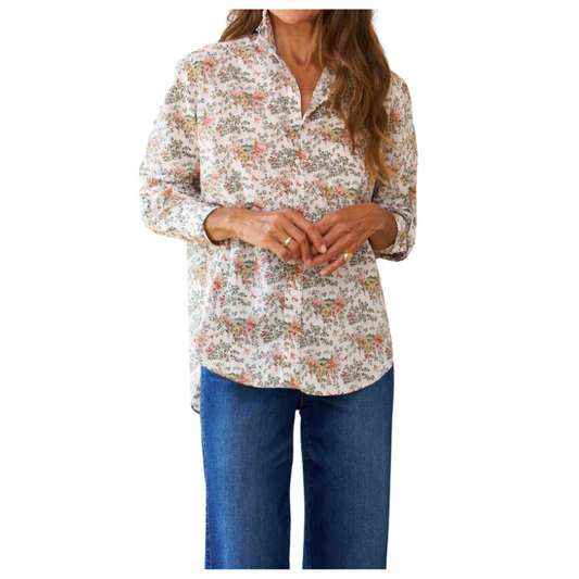 Woman wearing a floral blouse and blue jeans on a white background