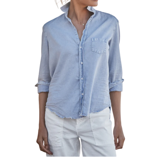 Person wearing a light blue button-up shirt and white pants on a white background