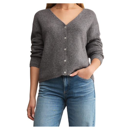 Person wearing a gray cardigan and blue jeans on a white background