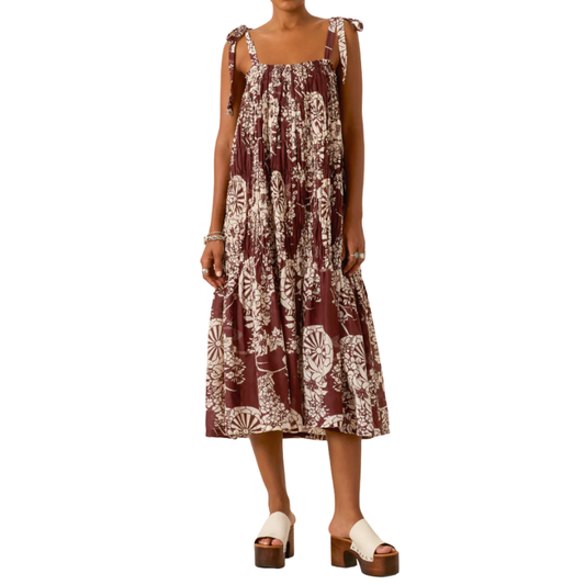 Woman wearing a sleeveless dress with a floral pattern on a white background