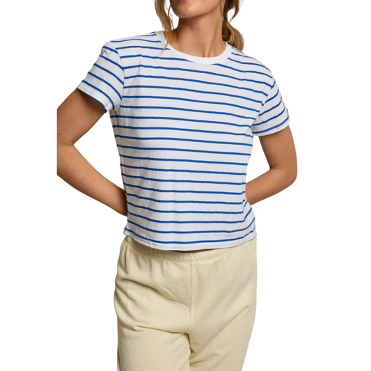 Person wearing a blue and white striped shirt with beige pants on a white background