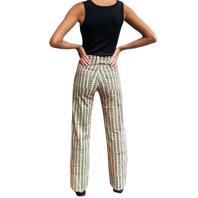 Person wearing a black sleeveless top and patterned pants on a white background