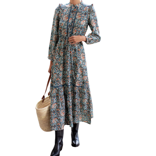 Woman wearing a floral dress holding a woven bag on a white background