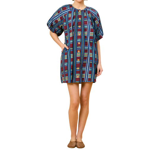 Woman wearing a colorful patterned dress on a white background