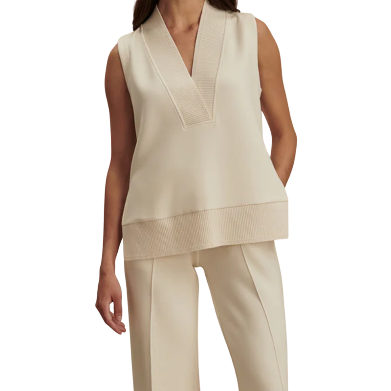 Woman wearing a beige sleeveless top and pants on a white background