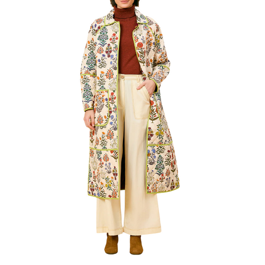 Person wearing a long floral-patterned coat on a white background
