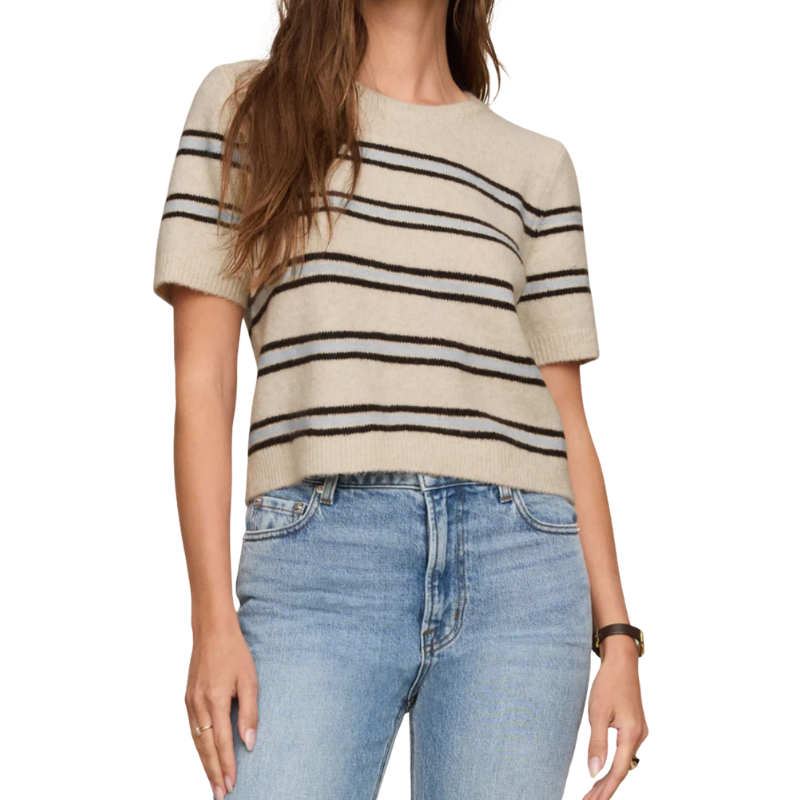 A woman wearing a short-sleeve knit sweater with horizontal black stripes on a cream base, paired with light blue jeans, shown against a plain white background.