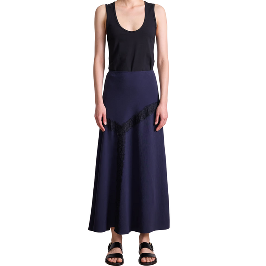 Person wearing a black sleeveless top and navy blue skirt on a white background