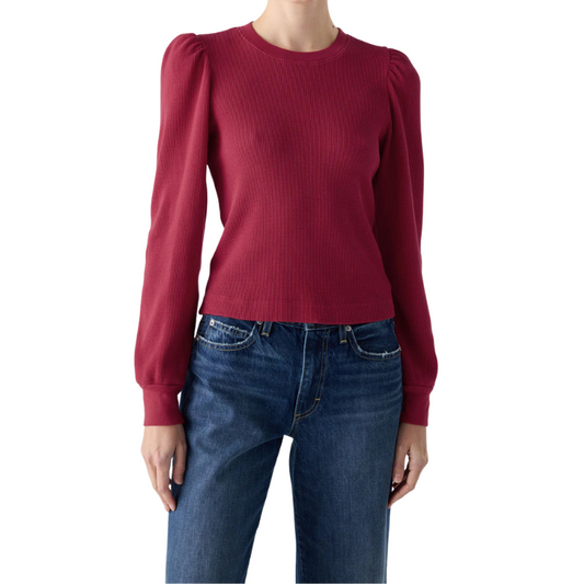 Red sweater with puff sleeves worn by a person on a white background