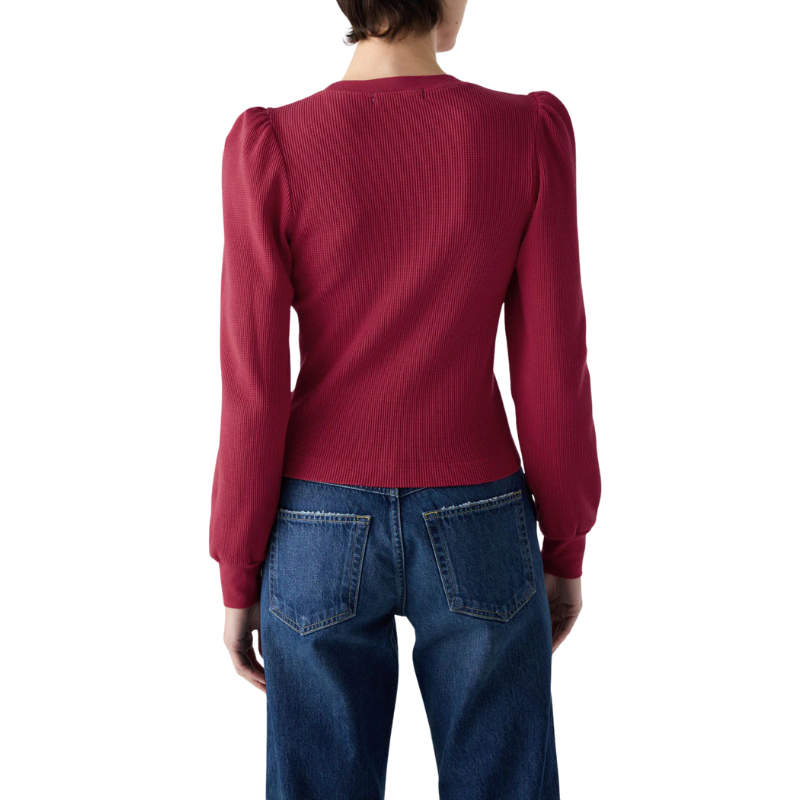 Person wearing a red sweater and blue jeans on a white background
