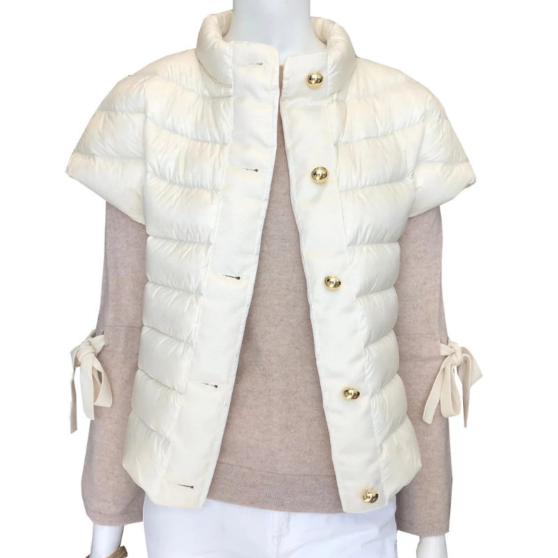 White puffer vest with gold buttons on a mannequin against a white background