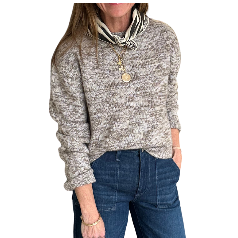Person wearing a marled sweater and jeans with a white background