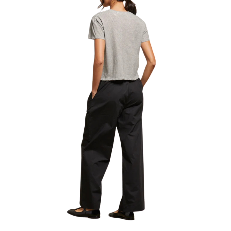 Person wearing a gray t-shirt and black pants on a white background