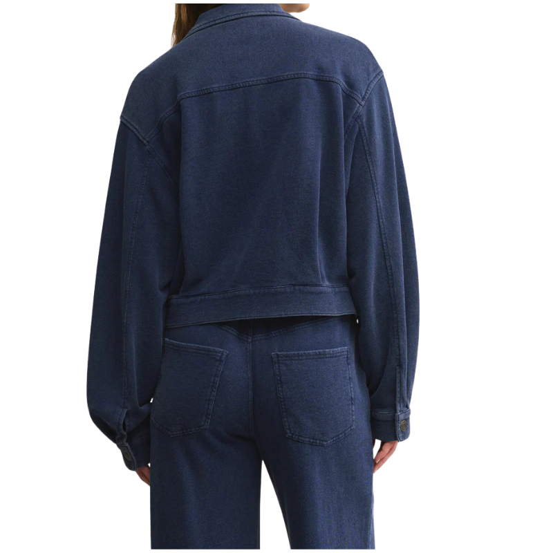 Person wearing a blue denim jacket and pants on a white background