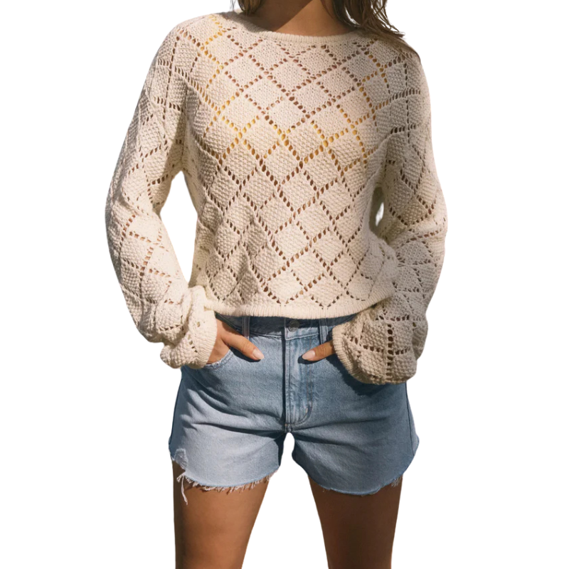 Beige knitted sweater worn by a person on a white background