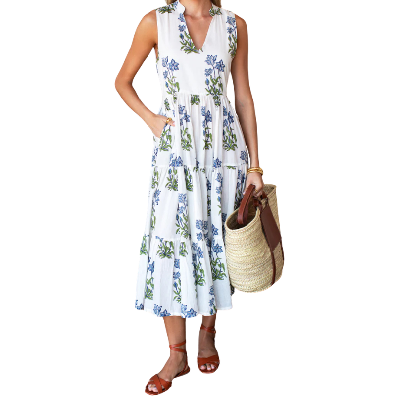 Woman wearing a white floral dress holding a straw bag on a white background