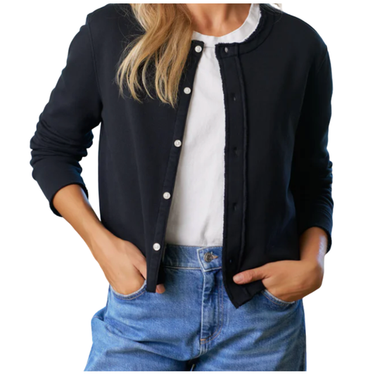 Person wearing a black cardigan over a white shirt and blue jeans on a white background