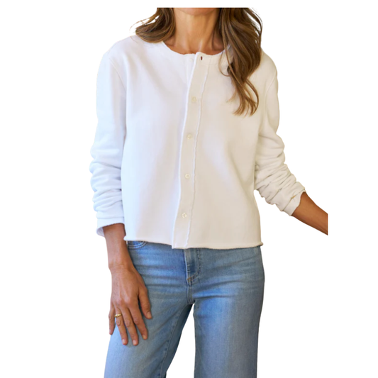 Woman wearing a white cardigan over a light blue shirt with jeans on a white background