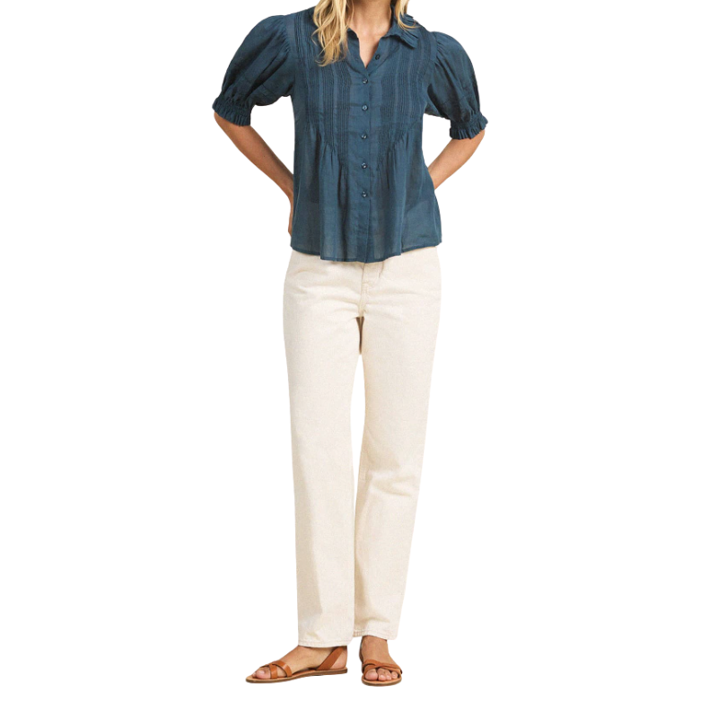Woman wearing a blue shirt and white pants on a white background