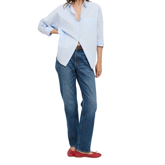 Person wearing a light blue shirt and blue jeans on a white background