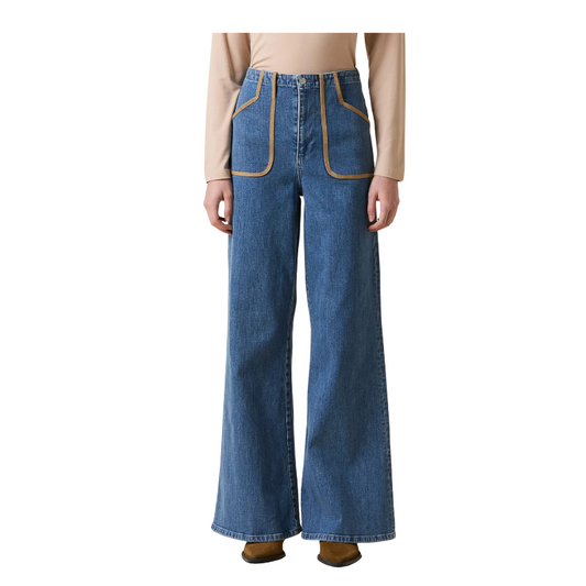Blue jeans with brown accents worn by a person on a white background