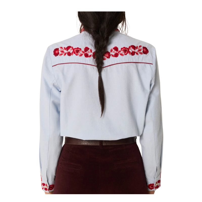 White blouse with red floral embroidery on a white background