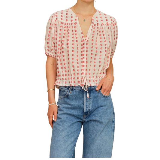 Person wearing a red and white patterned blouse with blue jeans on a white background