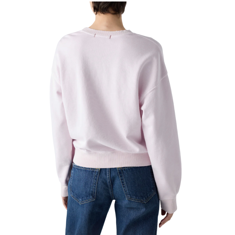 Person wearing a light purple sweater and blue jeans on a white background