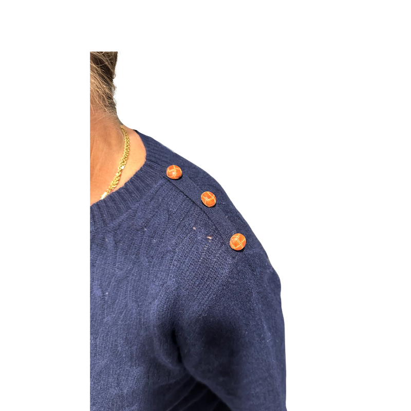 Navy blue sweater with orange buttons on a white background