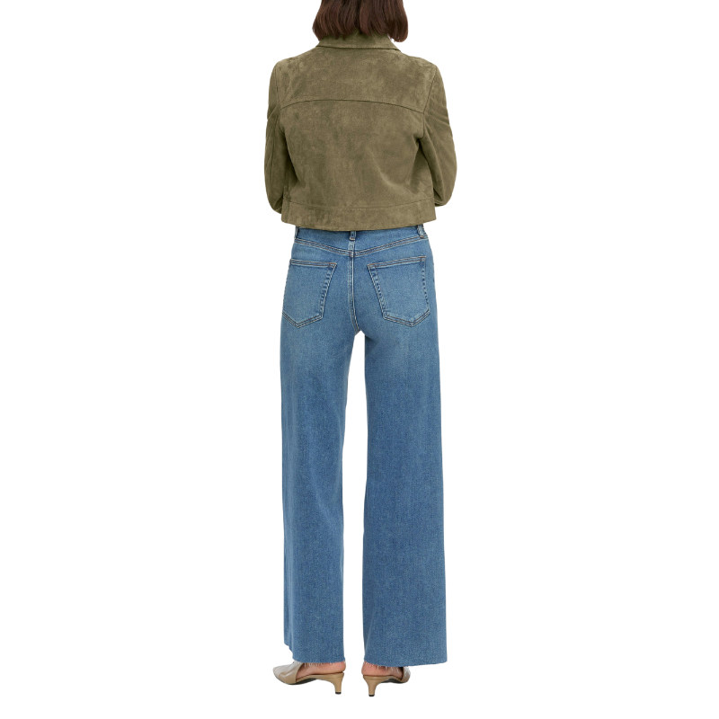 Person wearing a green jacket and blue jeans on a white background