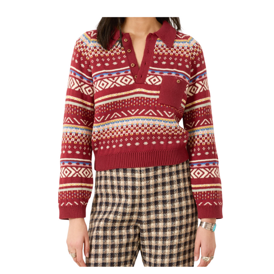 Person wearing a red patterned sweater and plaid pants on a white background
