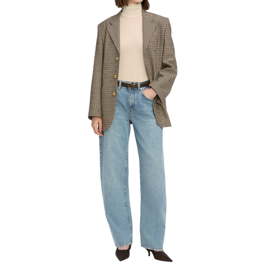 Person wearing a plaid blazer, beige turtleneck, and light blue jeans on a white background