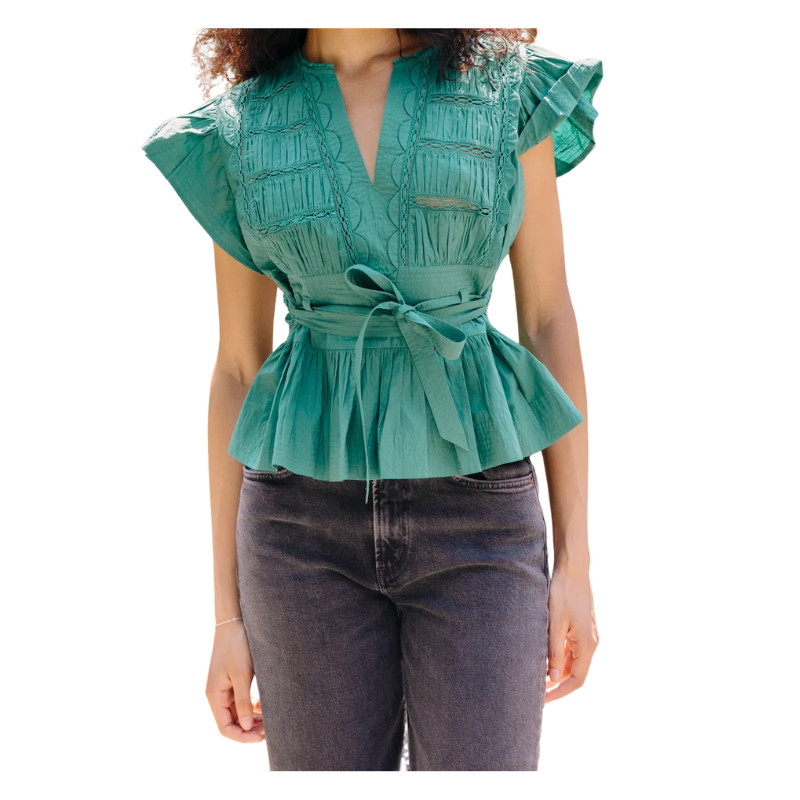 Green peplum top worn by a person on a white background