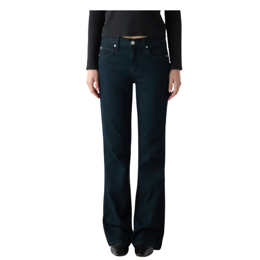 Person wearing dark blue flared jeans on a white background