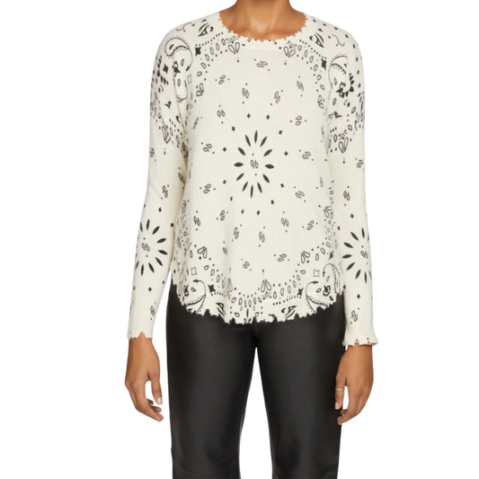 White long-sleeve top with black pattern worn by a person on a white background