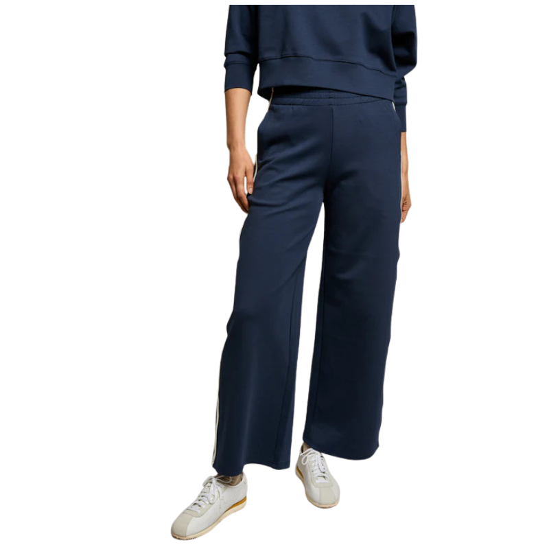 Person wearing navy blue pants and a matching top on a white background