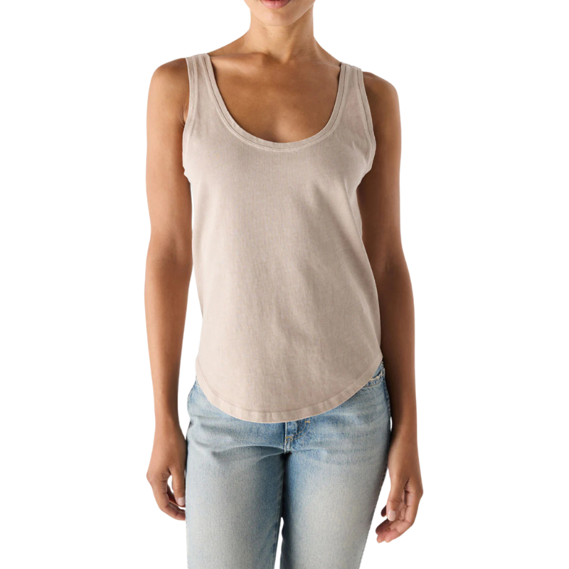 Person wearing a beige tank top and light blue jeans on a white background