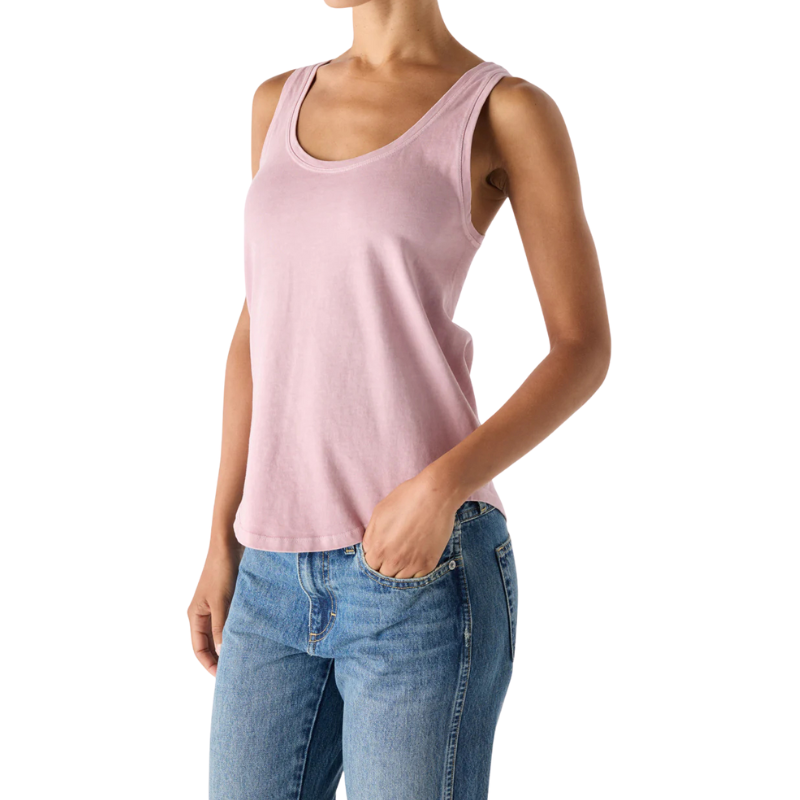 Person wearing a pink tank top and blue jeans on a white background