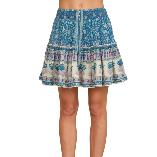 Blue and white patterned skirt worn by a person on a white background